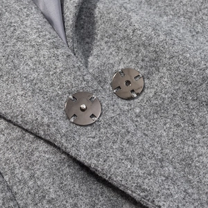 Détail d'un blazer en laine grise avec boutons en métal et doublure en soie
