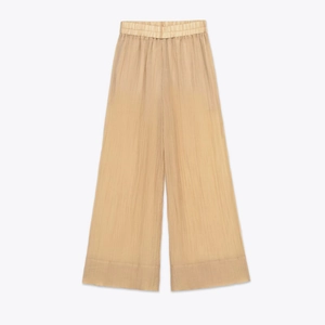 Détail d'un pantalon large marron clair avec taille élastique plissée et tissu texturé