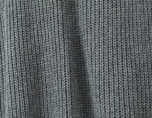 Primer plano de la textura de punto acanalado gris en el cárdigan largo para mujer