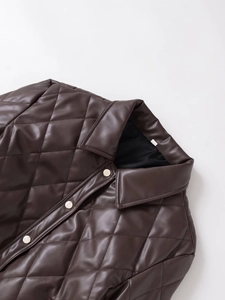 Close-up of quilted PU leather jacket showing snap buttons and refined lapel texture
