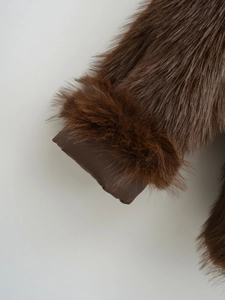 Detailed close-up of thick dark brown faux fur cuffs on a plush winter coat sleeve