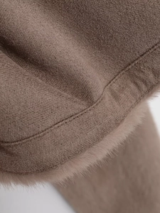 Detailed close-up of coffee brown faux fur trim and precision double-stitching on jacket sleeve