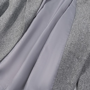 Gros plan sur la texture en tweed gris et la doublure lisse de la veste en laine