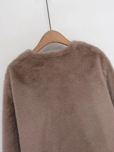 Detailed view of dark brown faux fur jacket texture and collar on a wooden hanger