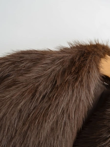 Close-up of deep brown faux fur coat showing dense texture and smooth lining