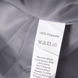 Gros plan sur l'étiquette d'entretien 100 % polyester et la texture du tissu du costume