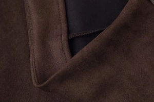 Detail of dark brown faux suede fabric with fine stitching and black lining texture