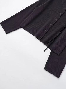 Detailaufnahme der anthrazitfarbenen Rippstrick-Textur von Strickjacke und passender Hose