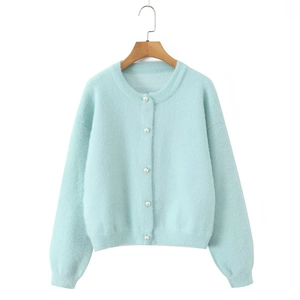 Détail d'un cardigan en maille bleu clair avec d'élégants boutons en perles blanches