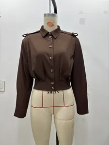 Détail de la taille plissée et des pattes d'épaule décoratives sur cette chemise brune