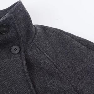 Close-up of charcoal grey wool coat with stand collar and textured fabric detail
