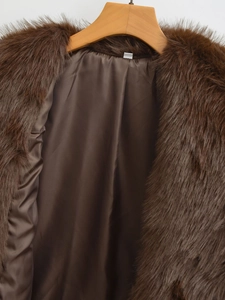 Close-up of dark brown faux fur coat collar with smooth satin lining on wood hanger