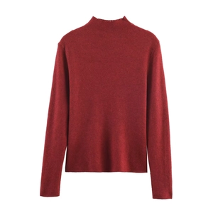 Detailed view of the fine ribbed texture and turtleneck collar on red knitted top