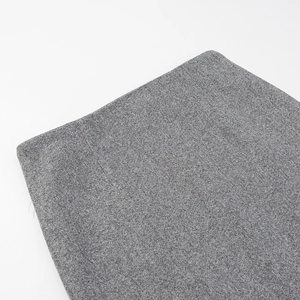 Gros plan sur la texture du tissu en laine grise et les coutures de la taille de la jupe