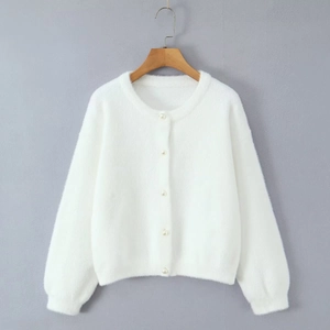Détail d'un gilet blanc doux à col rond avec des boutons en perles élégantes