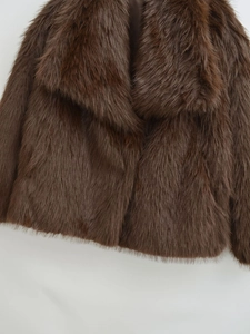 Close-up detail of plush dark brown faux fur texture and lapel of the stylish winter coat