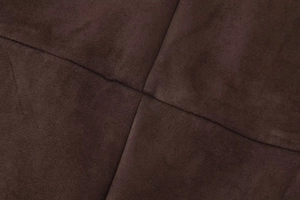 Detail shot of criss-cross stitching on thick dark brown faux suede fabric