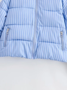 Detail of blue striped puffer jacket featuring metal zippers and quilted texture
