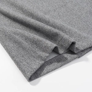 Détail de la texture en maille gris chiné avec couture d'ourlet soignée sur le costume blazer
