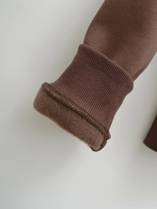 Detail of ribbed cuffs and warm brown fleece lining on a winter hoodie sweatshirt