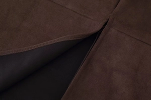Detail of brown faux suede skirt featuring a side slit and clean black inner lining