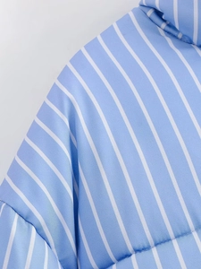 Close-up of blue and white vertical striped puffer jacket fabric with fine stitching