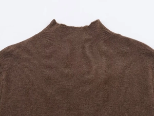 Detailed view of the dark brown mock neck knit top featuring a ribbed vertical texture