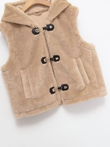 Détail du gilet à capuche en fausse fourrure avec boucles en cuir noir et anneaux dorés