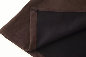 Detail of dark brown faux suede fabric with precise stitching and black inner lining
