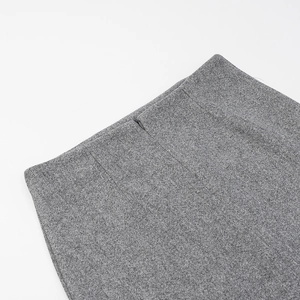 Détail de la fermeture éclair invisible et du tissu en laine gris sur la taille de la jupe