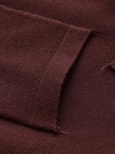 Macro della trama in maglia bordeaux con tessitura a maglia piatta e dettagli di cucitura