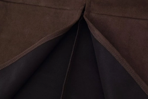 Macro shot of dark brown suede fabric with split detail and neat stitching finish