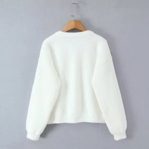 Vue détaillée du tissu en maille pelucheuse blanche avec texture douce et col rond soigné