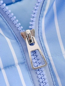 Macro shot of silver metal zipper on light blue striped jacket with ribbed texture