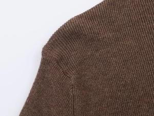 Close-up of brown ribbed knit sweater shoulder showing fine vertical texture and soft fabric