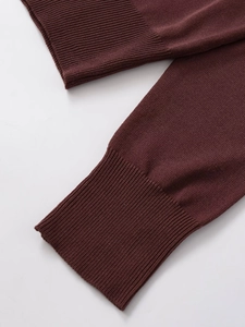 Dettaglio dei polsini a costine su un maglione polo in maglia fine in marrone scuro