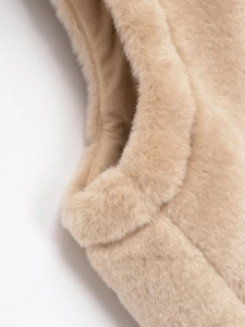 Gros plan sur la texture en fausse fourrure beige d'un gilet avec tissu pelucheux doux