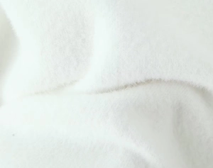Gros plan sur le tissu en peluche blanc doux et la texture veloutée du gilet en maille