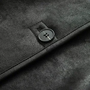 Close-up of premium dark grey leather texture and fine stitching with black resin button
