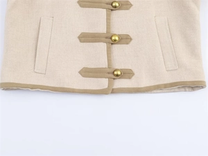 Detail of beige tweed jacket featuring gold buttons and brown contrast trim decoration