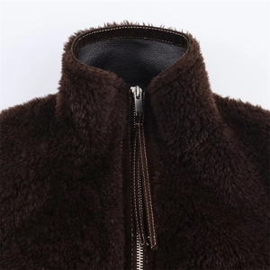 Detail of faux fur jacket collar featuring dark brown plush texture and leather trim zippers
