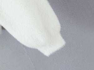 Détail montrant la texture douce de la fausse fourrure blanche et de la laine pelucheuse