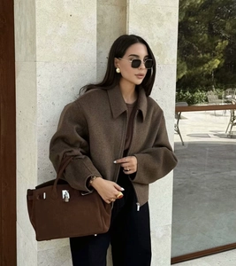 Detailed texture of brown wool jacket featuring stand collar and heavy fabric quality