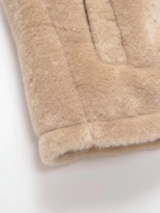 Gros plan sur la fourrure synthétique beige épaisse avec coutures sur le gilet à capuche