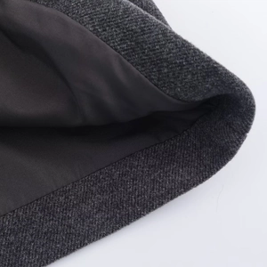 Detailed close-up of dark grey wool blend coat with smooth black inner lining