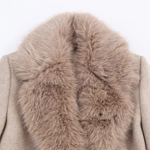 Dettaglio del cappotto in lana cammello con collo in ecopelliccia e trama del tessuto