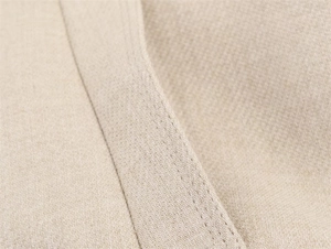 Macro detail of beige jacket fabric showing premium double-stitching and fine texture