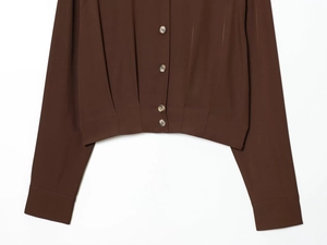Détail de la taille plissée marron café et de la fermeture à boutons sur la blouse