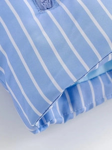 Macro detail of blue and white striped fabric with branded WY zipper on the jacket