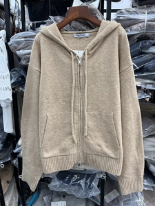 Close-up of khaki hooded knit cardigan with metal zipper and ribbed cuffs details